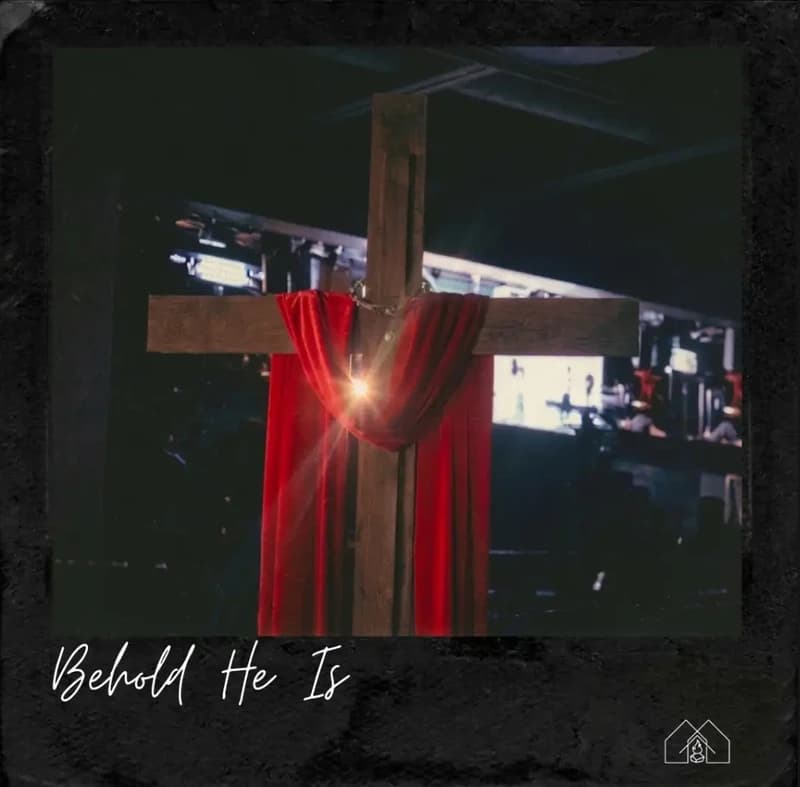 Behold He Is album cover: a wooden cross draped in red cloth